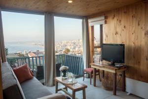 a living room with a couch and a television on a balcony at Hotel Faro Azul Valparaíso Cerro Alegre in Valparaíso
