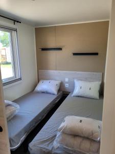 2 aparte bedden in een kamer met een raam bij Perle des îles in Lège-Cap-Ferret