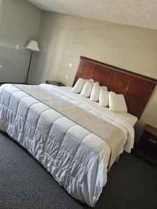 Habitación de hotel con cama grande con almohadas blancas en Platte Valley Inn en Columbus