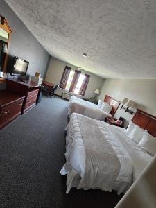 a hotel room with two beds and a television at Platte Valley Inn in Columbus
