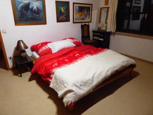 um quarto com uma cama com um cobertor vermelho e branco em Haus Wagner em Schiltach