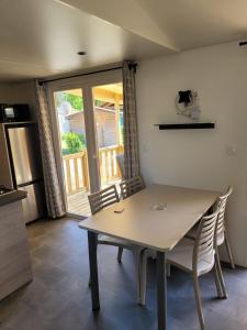 een tafel en stoelen in een keuken met een raam bij Perle des îles in Lège-Cap-Ferret