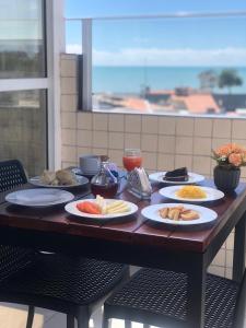 a wooden table with plates of food on it at Hotel Pousada Kairos Manaira in João Pessoa