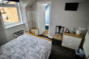 a bedroom with a bed and a window and a television at Hunters Guest House in Brodick