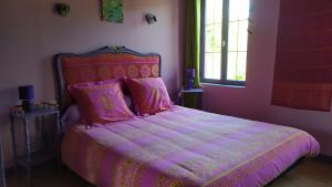 Dormitorio rosa con cama con sábanas y almohadas rosas en Chambres d'Hôtes Le Relais du Passage de la Roche, en Le Mesnil-sous-Jumièges