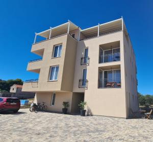a large apartment building in a parking lot at Casa Mili - Ante & Marta in Jezera
