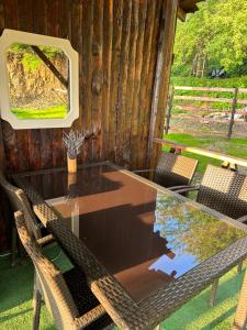 una mesa de cristal con sillas y una ventana en una cabaña en Bear House Uludağ Bungalov en Hüseyinalan