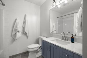 a white bathroom with a toilet and a sink at Beautiful Renovated Wolf 2Bed 2Bath in Canmore +35 photos