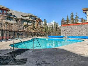 ein Pool in einem Garten mit einem Zaun in der Unterkunft Beautiful Renovated Wolf 2Bed 2Bath in Canmore