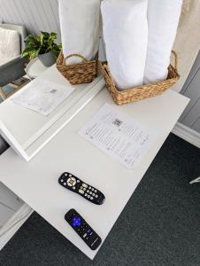 un telecomando seduto su un tavolo accanto agli asciugamani di Tower Circle Motel a Buxton
