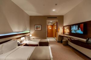 a hotel room with two beds and a flat screen tv at Zirve Hotel in Shahdag