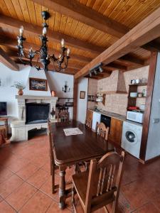 a kitchen and dining room with a wooden table and chairs at Tio Claudio in El Barraco