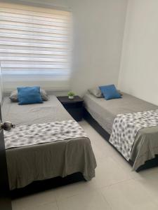 2 camas en una habitación con ventana en Apartamento Cerca al mar en Cartagena de Indias