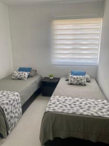 twee bedden in een kamer met een raam bij Apartamento Cerca al mar in Cartagena