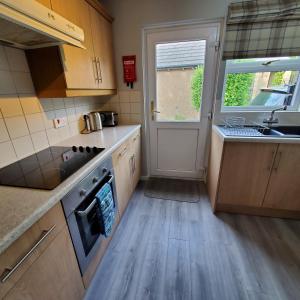 a kitchen with a sink and a stove top oven at Aviemore Bungalow, Dalfaber in Aviemore