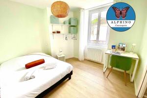 1 dormitorio con cama, escritorio y cartel de mariposa en L'Aristide, calme et moderne en Limoges