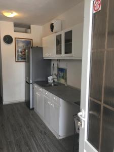 a kitchen with white cabinets and a stainless steel refrigerator at Apartments Sun & Sea in Vodice