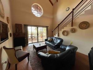 a living room with a leather couch and a table at Hakuna Matata-Bela Bela in Moheme