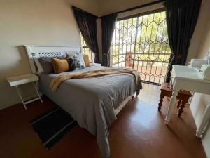 a bedroom with a bed and a large window at Hakuna Matata-Bela Bela in Moheme