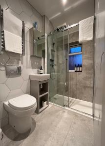 een badkamer met een douche, een toilet en een wastafel bij Red Brick House in Yeovil