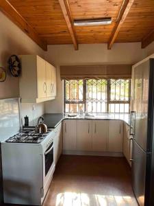 a kitchen with white cabinets and a stove top oven at Hakuna Matata-Bela Bela in Moheme