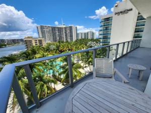 a balcony with a view of the beach and palm trees at Modern Waterfront Retreat with Scenic Views in Hollywood
