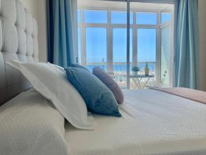 a bedroom with a bed with pillows and a window at ALAY PUERTO MARINA in Benalmádena