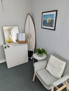 a room with a chair and a surfboard in it at Tower Circle Motel in Buxton