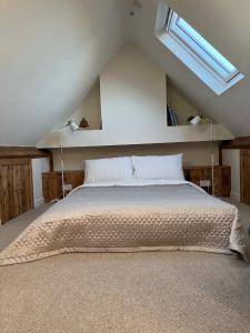 a bedroom with a large bed with a skylight at Red Brick House in Yeovil