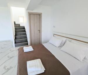 una camera da letto con un grande letto con due asciugamani di Blue Dream Afytos ad Áfitos