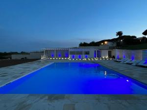 una piscina por la noche con luces azules en Euphoria Resort, en Olgiata