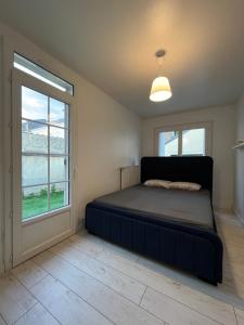 een slaapkamer met een bed en een raam bij Charmante Mancelle 24h hyper centre in Le Mans