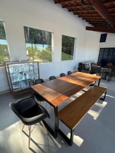 una mesa de madera y sillas en una habitación con ventanas en CBI155 Casa de campo em Itatiba, en Itatiba