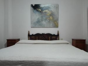 a bedroom with a bed and a painting on the wall at Posada de San Agustin in Pátzcuaro