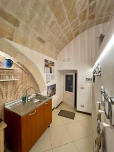 kuchnia ze zlewem i ceglaną ścianą w obiekcie Dimora Aversa w mieście Monopoli