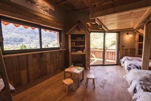 a room with two beds and a table and windows at Chalet de prestige Pyrénéen, 3 min des télécabines in Vignec