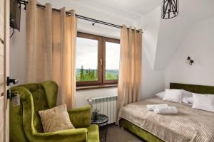 - une chambre avec un lit, une chaise et une fenêtre dans l'établissement Gościniec u Antka, à Poronin