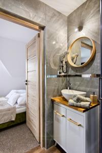 La salle de bains est pourvue d'un lavabo et d'un miroir. dans l'établissement Gościniec u Antka, à Poronin