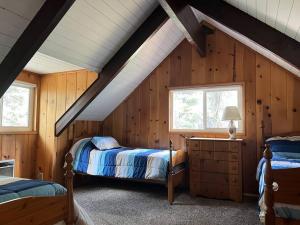 - une chambre mansardée avec 2 lits et 2 fenêtres dans l'établissement Lake Almanor Country Club Rustic Retro Cottage, à Prattville