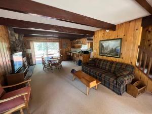 sala de estar con sofá y mesa en Lake Almanor Country Club Rustic Retro Cottage en Prattville