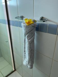 a towel with a yellow flower on it hanging in a shower at Pousada Luna in Fernando de Noronha