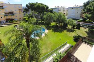 Blick auf einen Park mit Palmen und Gebäuden in der Unterkunft New Golden 5 Planetcostadorada in Salou