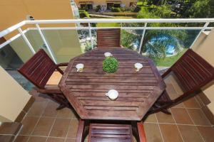 einen Holztisch mit zwei Stühlen und eine Pflanze auf dem Balkon in der Unterkunft New Golden 5 Planetcostadorada in Salou