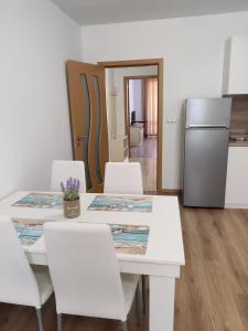 a kitchen with a table with white chairs and a refrigerator at Villa Rossa in Ravda +19 photos