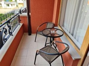 a table and a chair on a balcony at Villa Rossa in Ravda