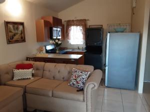 a living room with a couch and a refrigerator at Sassy Diamond Crest in Portmore