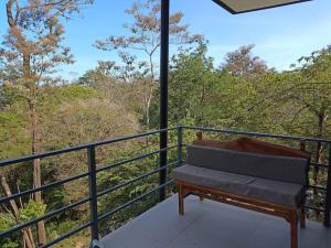 a bench sitting on top of a balcony with trees at Laurel Jungle & Ocean in Santa Teresa Beach
