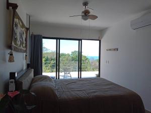 1 dormitorio con cama y ventana grande en Laurel Jungle & Ocean, en Santa Teresa Beach