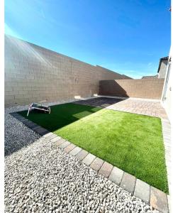 a patch of green grass next to a brick wall at NEW House, 2023 built, 5 bedrooms, Sleeps 12, Near Las Vegas Strip and Airport in Las Vegas