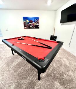 a red pool table in a room with a tv at NEW House, 2023 built, 5 bedrooms, Sleeps 12, Near Las Vegas Strip and Airport in Las Vegas